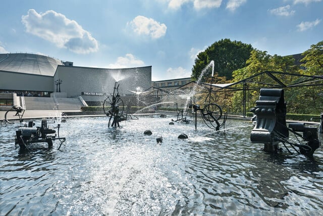 Der Fasnachtsbrunnen von Jean Tinguely auf dem Theaterplatz ist mit seinem fröhlichen Wasserspiel eine der beliebtesten Attraktionen der Stadt.
  ///  
With its playful water dance, the Fasnacht fountain by Jean Tinguely on Theaterplatz is one of the city's most popular attractions.