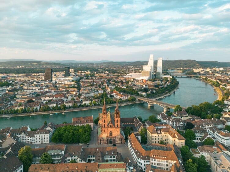 Drohnenaufnahme von Basel. Im Vordergrund das Basler Münster und im Hintergrund der Rhein und Kleinbasel mit den Rochetürmen.