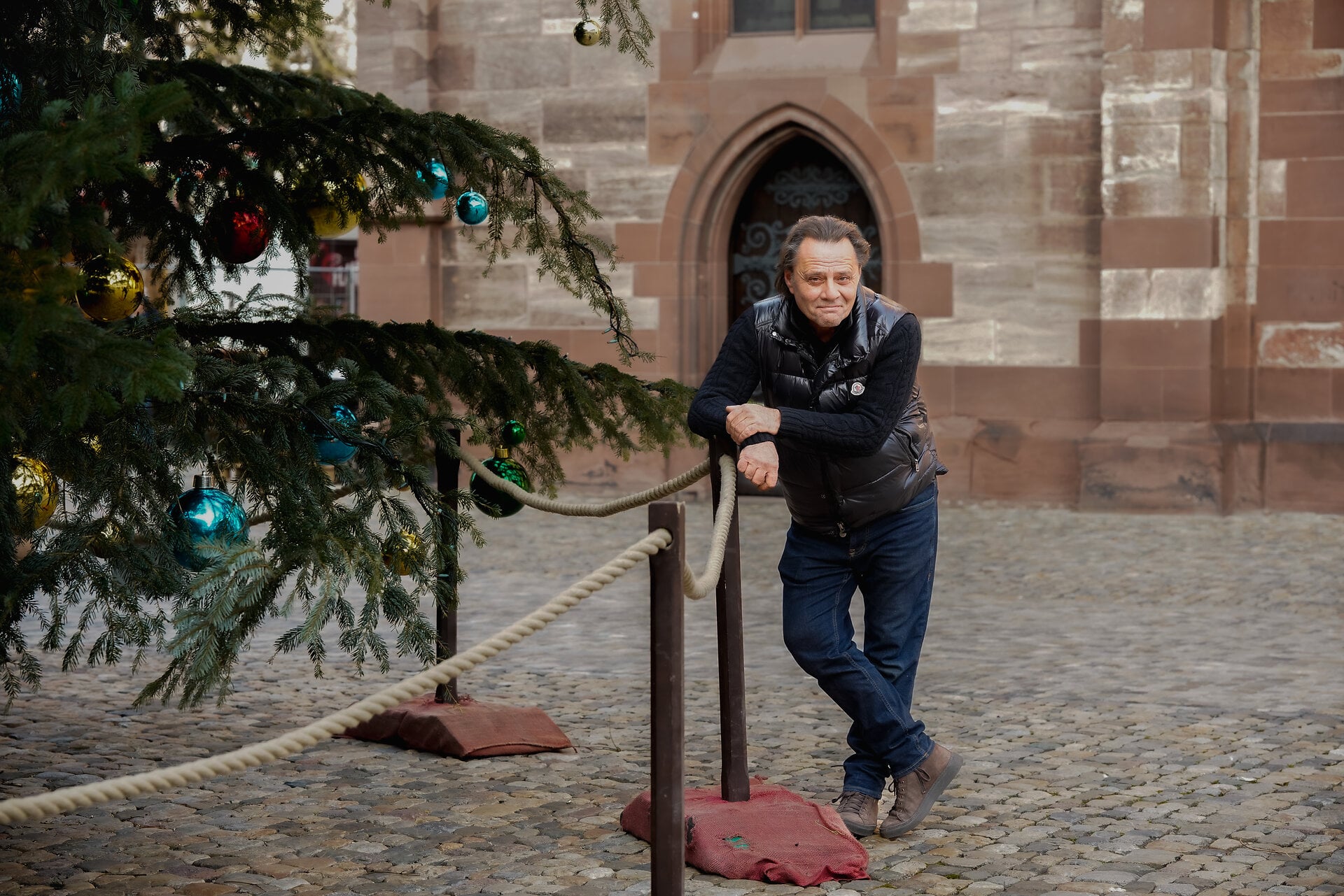 Heinz Margot accanto al grande albero di Natale sulla Münsterplatz. © Basel Tourismus, Oz Jacob Tabib