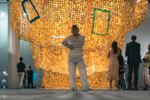 Die Künstlerin Sophie Lardon schaut an der Art Basel ein überdimensionales Kunstwerk an, welches wie ein Teppich in Wellenform herunterfällt.