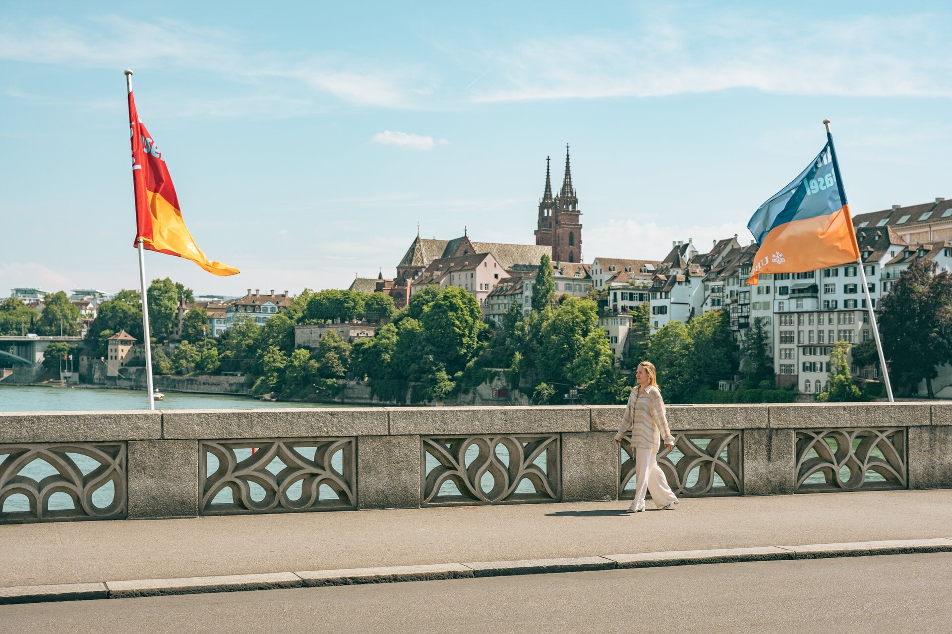 Die Künstlerin Sophie Lardon läuft über die Mittlere Brücke. Im Hintergrund sieht man das Basler Münster.