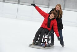Rollstuhl mit Eisgleiter auf der Kunsteisbahn