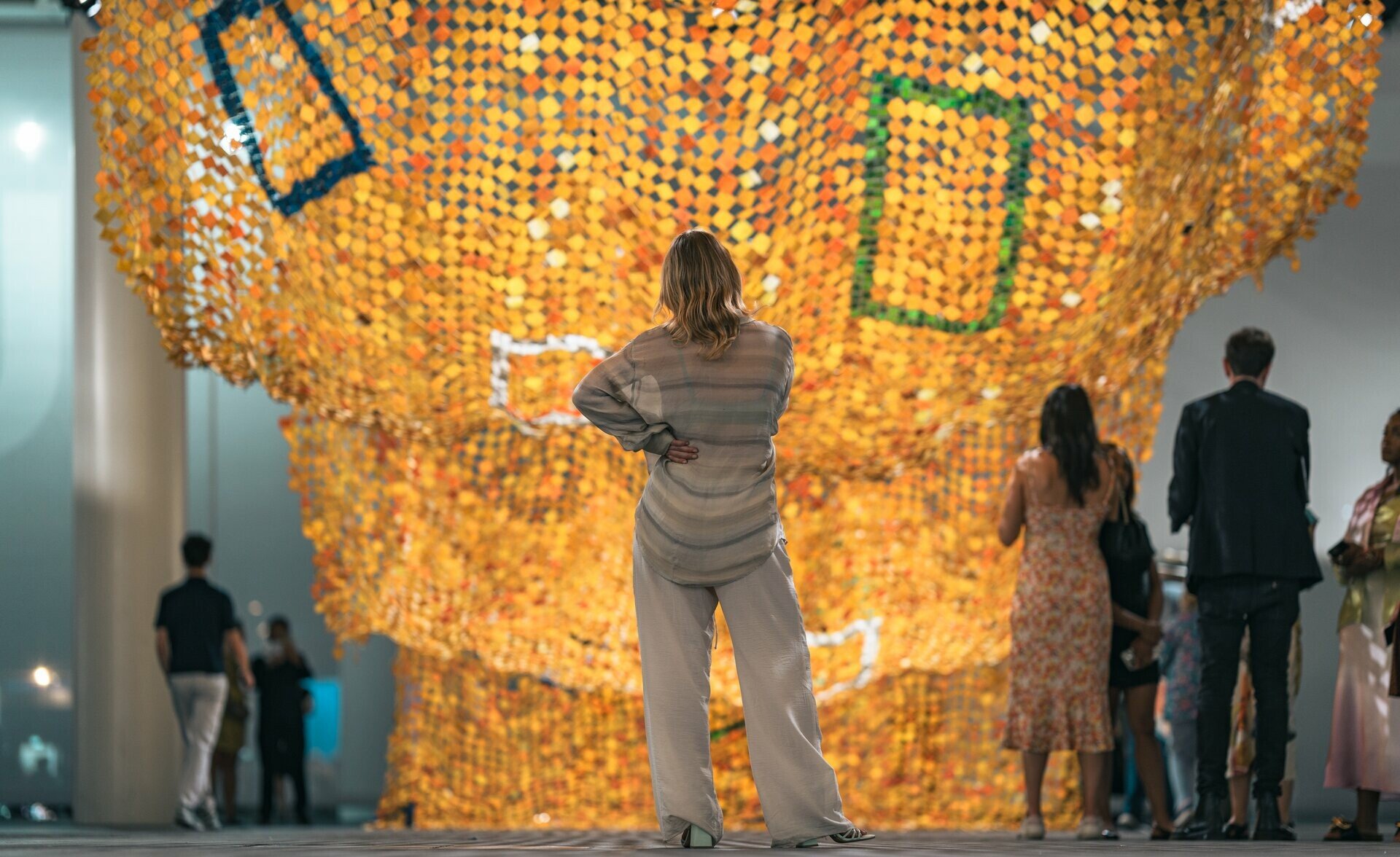 Die Künstlerin Sophie Lardon schaut an der Art Basel ein überdimensionales Kunstwerk an, welches wie ein Teppich in Wellenform herunterfällt.